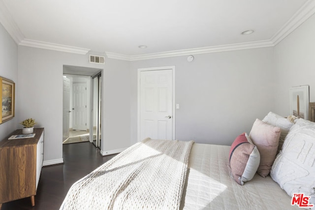 bedroom featuring crown molding and dark wood-type flooring