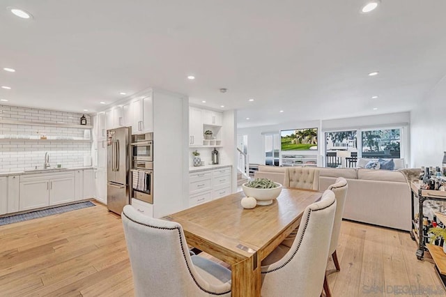 dining area featuring sink and light hardwood / wood-style floors