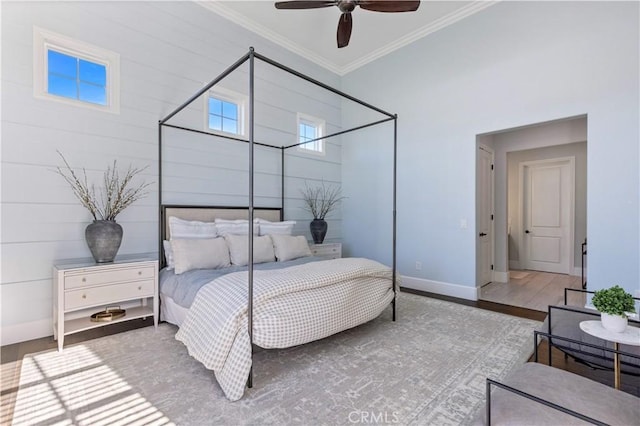 bedroom featuring hardwood / wood-style floors, ornamental molding, and ceiling fan