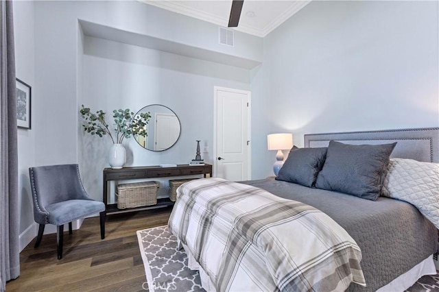 bedroom featuring dark hardwood / wood-style flooring, ornamental molding, and ceiling fan