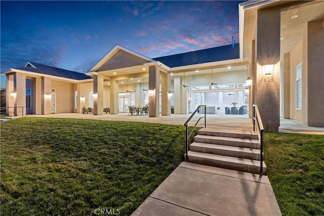 view of front of home featuring a patio and a lawn