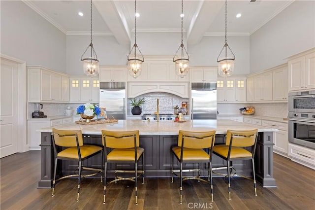 kitchen with a spacious island, appliances with stainless steel finishes, decorative light fixtures, and backsplash