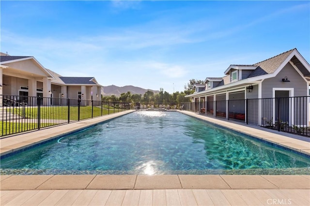 view of swimming pool with a mountain view and a lawn