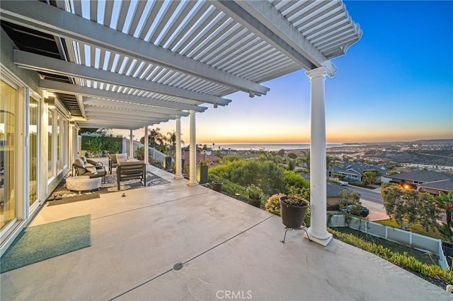 patio terrace at dusk with an outdoor living space and a pergola