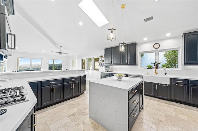 kitchen featuring a healthy amount of sunlight, a center island, and sink