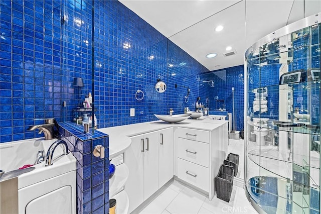 bathroom featuring tile patterned floors, vanity, tile walls, and a washtub