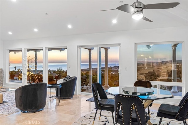 sunroom / solarium with a water view, a wealth of natural light, and ceiling fan