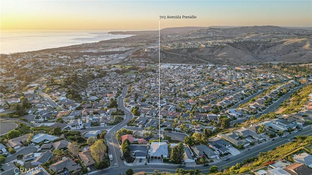 aerial view at dusk featuring a water view