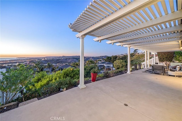 patio terrace at dusk featuring a pergola