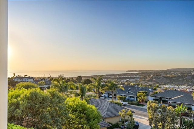 aerial view at dusk featuring a water view