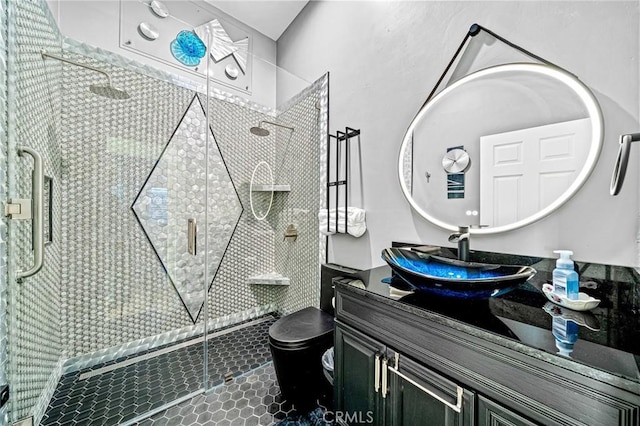 bathroom featuring a shower with door, vanity, and toilet