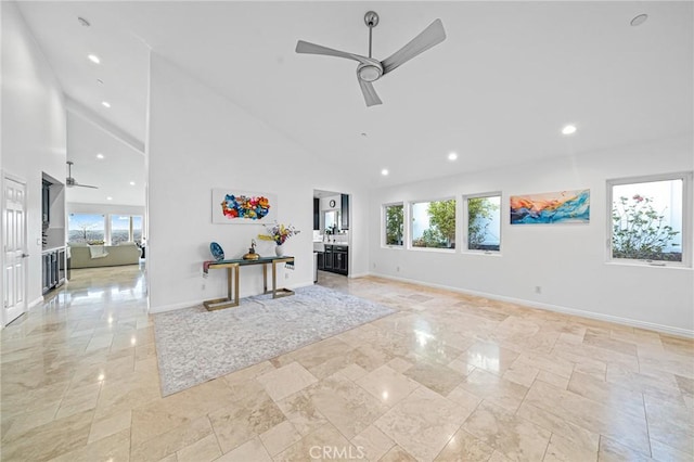 unfurnished living room with high vaulted ceiling and ceiling fan