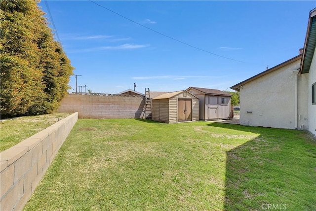 view of yard featuring fence private yard, a storage shed, and an outdoor structure