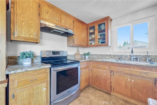 kitchen with light stone countertops, light tile patterned flooring, a sink, stainless steel range with electric cooktop, and under cabinet range hood