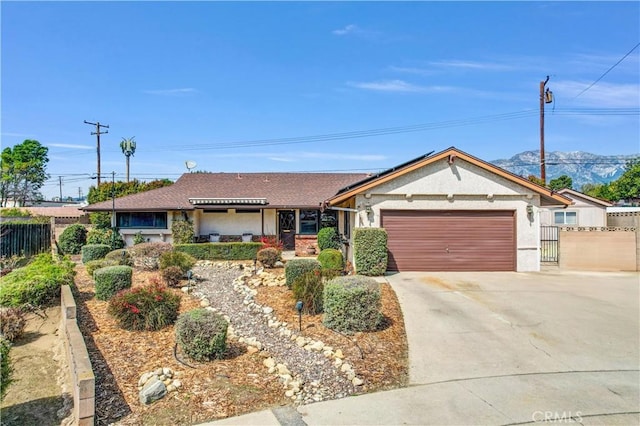 ranch-style house featuring stucco siding, driveway, an attached garage, and fence