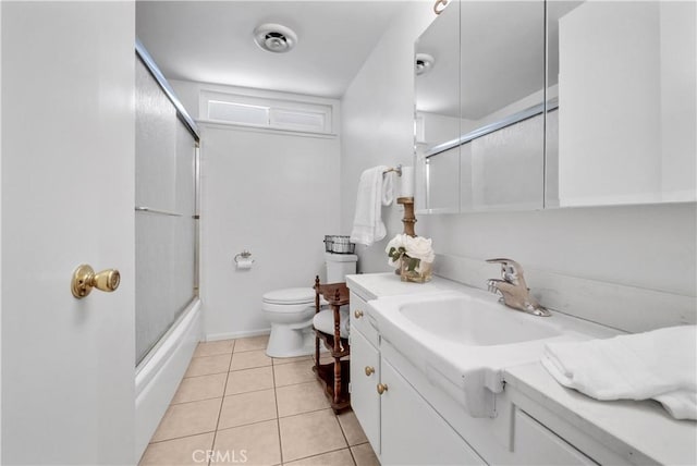 bathroom with vanity, toilet, shower / bath combination with glass door, and tile patterned flooring