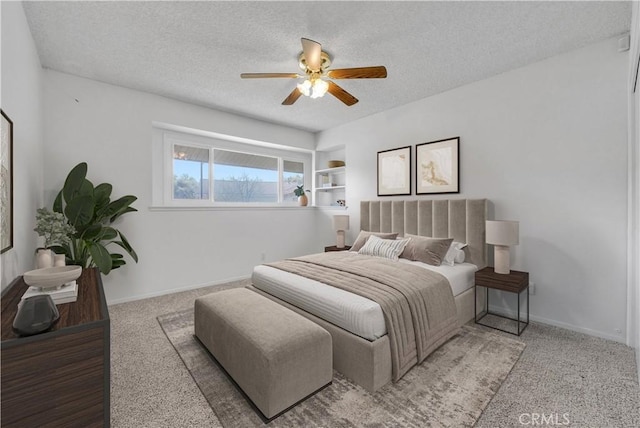 bedroom with baseboards, a textured ceiling, ceiling fan, and carpet