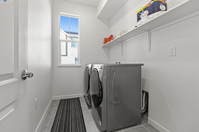 laundry area with light tile patterned floors and washing machine and dryer