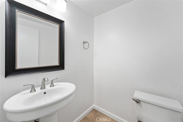 bathroom featuring toilet, sink, and tile patterned flooring