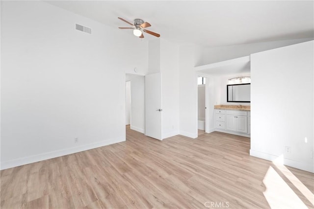 unfurnished living room with high vaulted ceiling, ceiling fan, and light hardwood / wood-style flooring