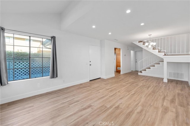 unfurnished living room featuring light hardwood / wood-style floors and a chandelier