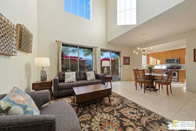 tiled living room featuring a high ceiling and a notable chandelier