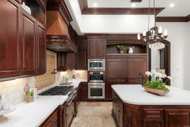 kitchen with appliances with stainless steel finishes, decorative light fixtures, an island with sink, decorative backsplash, and custom range hood