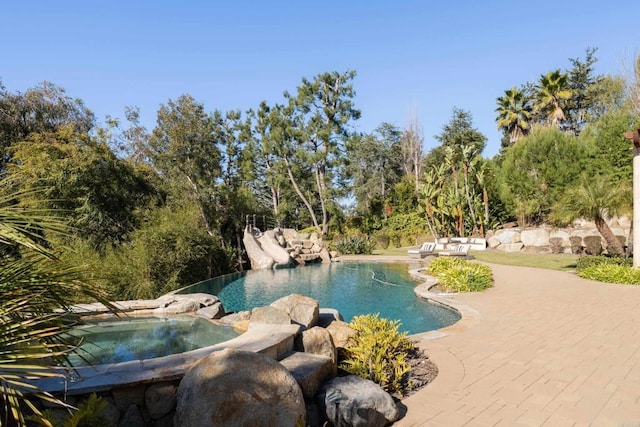 view of swimming pool with a patio area and an in ground hot tub