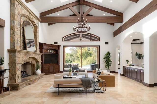 living room with an inviting chandelier, a stone fireplace, high vaulted ceiling, and beamed ceiling