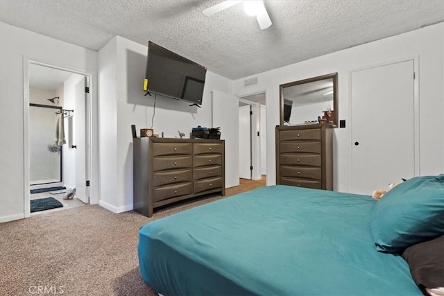 carpeted bedroom featuring ceiling fan, ensuite bathroom, and a textured ceiling