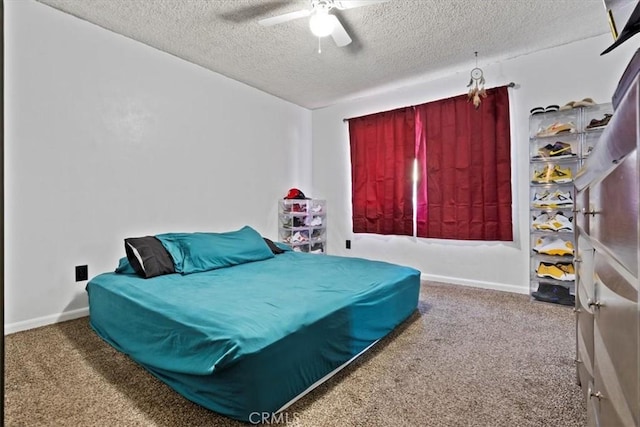 bedroom with ceiling fan, carpet floors, and a textured ceiling