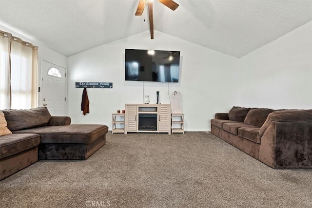 living room featuring ceiling fan, a fireplace, carpet flooring, and vaulted ceiling with beams