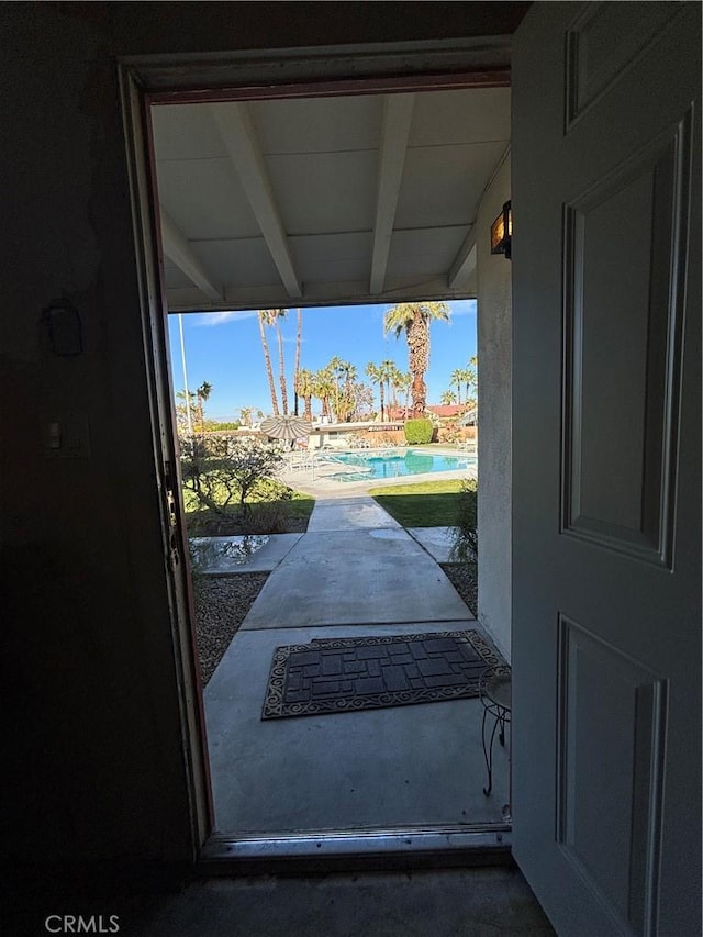 doorway to outside with a healthy amount of sunlight and beam ceiling