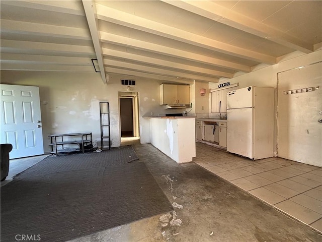 kitchen featuring white refrigerator, beam ceiling, and white cabinets