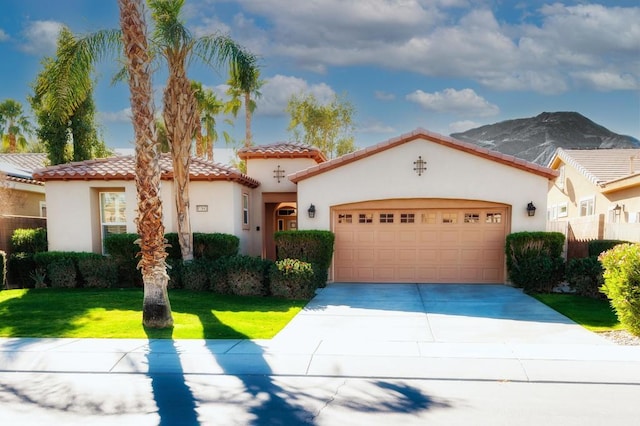 mediterranean / spanish home featuring a garage, a mountain view, and a front yard