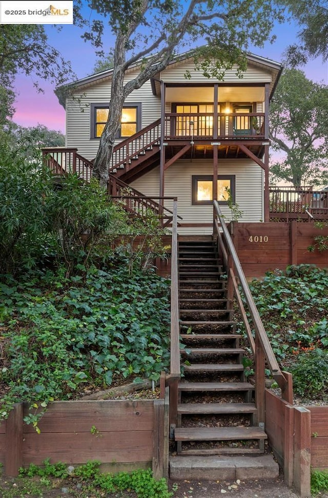 back house at dusk with a balcony