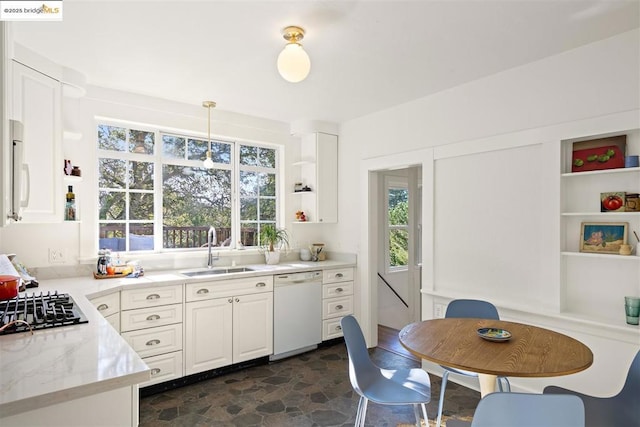 kitchen with sink, hanging light fixtures, white appliances, light stone countertops, and white cabinets