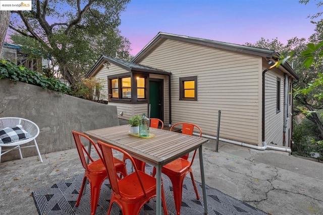 back house at dusk with a patio area