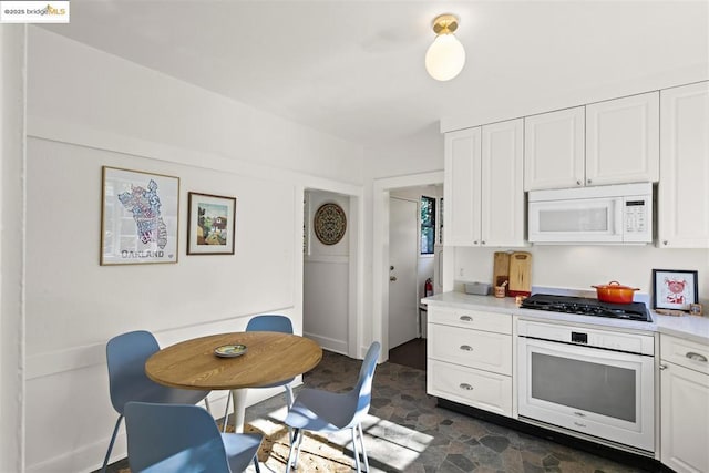 kitchen with white cabinetry and white appliances