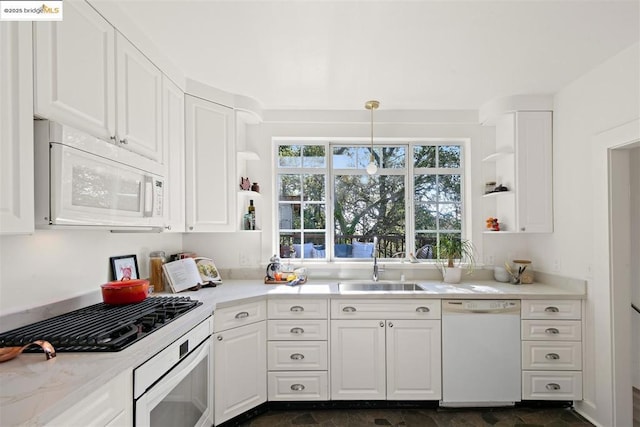 kitchen featuring pendant lighting, sink, white appliances, and white cabinetry