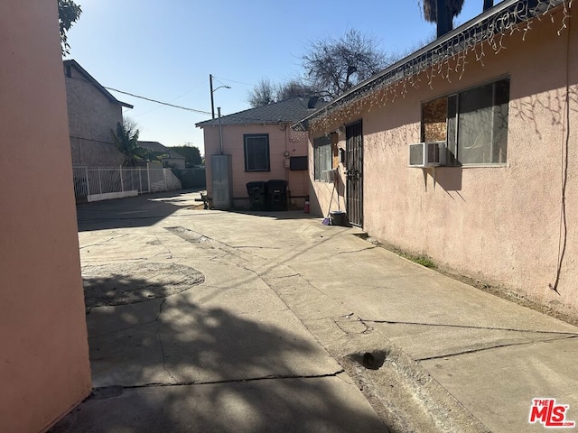 view of side of home featuring cooling unit and a patio