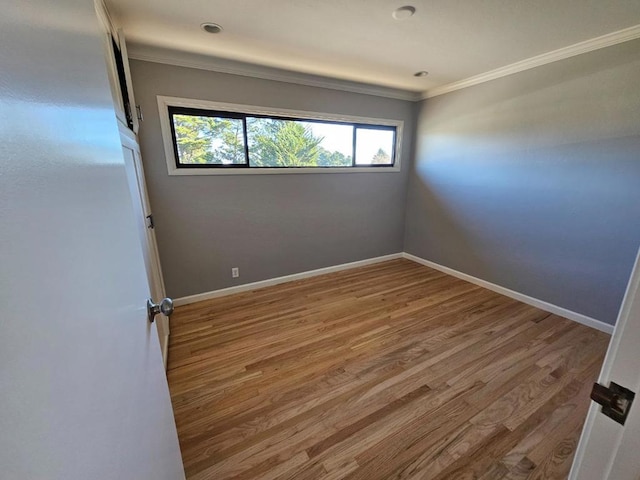 unfurnished room featuring hardwood / wood-style flooring and ornamental molding