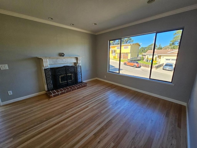 unfurnished living room featuring crown molding, a brick fireplace, and hardwood / wood-style flooring