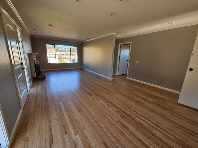 unfurnished living room featuring crown molding and wood-type flooring