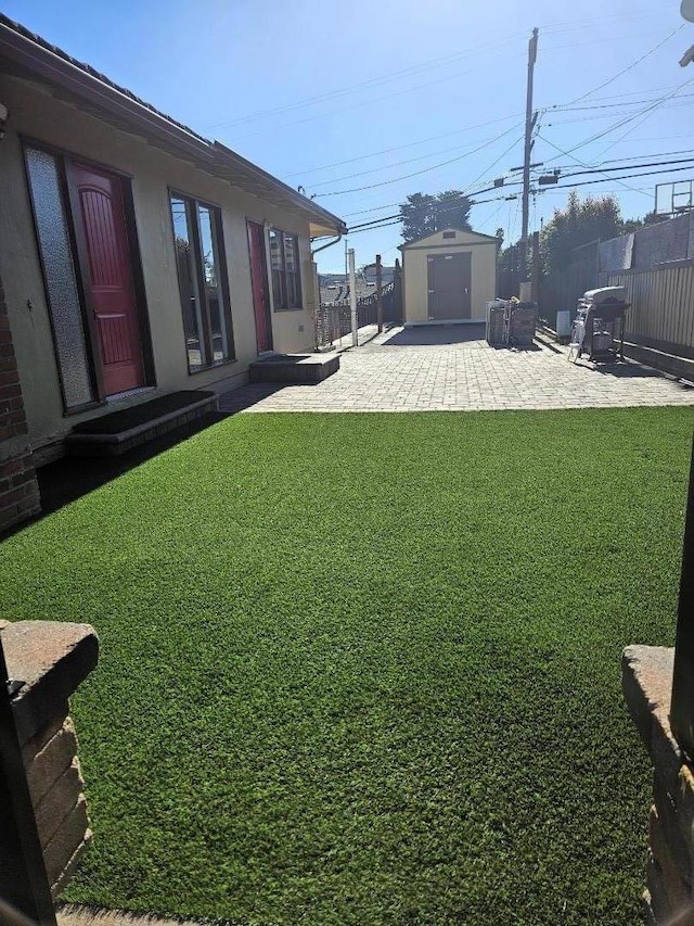 view of yard with a storage unit and a patio area