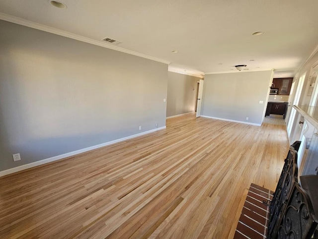 unfurnished living room featuring crown molding and light wood-type flooring