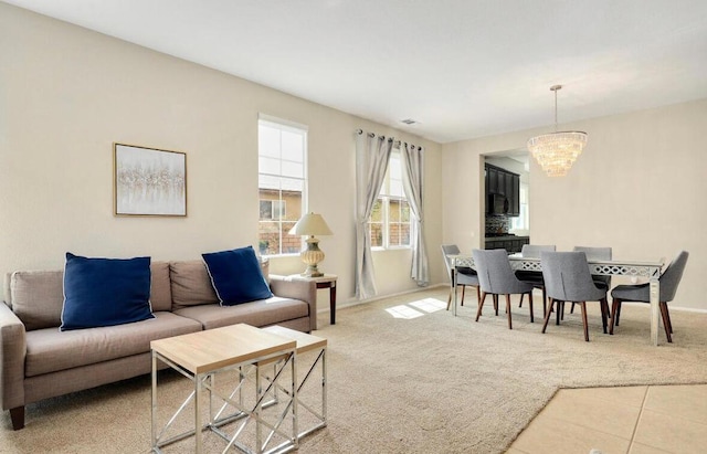 carpeted living room featuring a chandelier