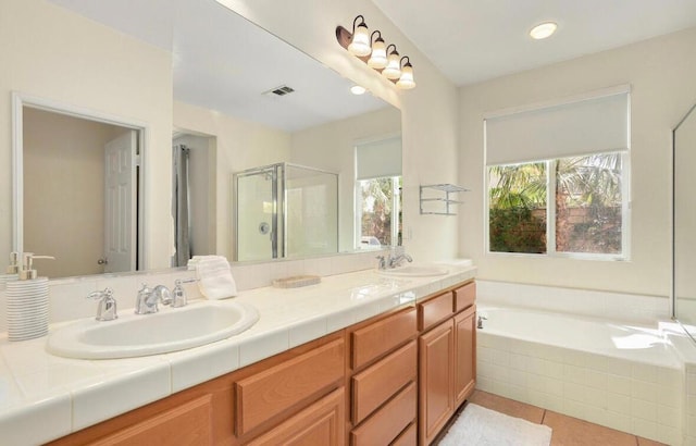 bathroom featuring vanity, tile patterned flooring, and plus walk in shower