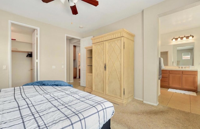 bedroom featuring ensuite bath, ceiling fan, light carpet, a spacious closet, and a closet