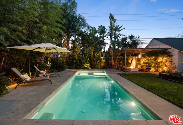 view of pool with a lawn, a patio area, and a fire pit